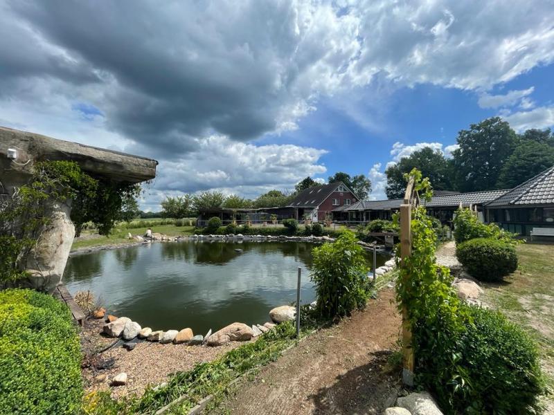 4.-zicht-over-grot-vijver-en-huis-met-donkere-wolken